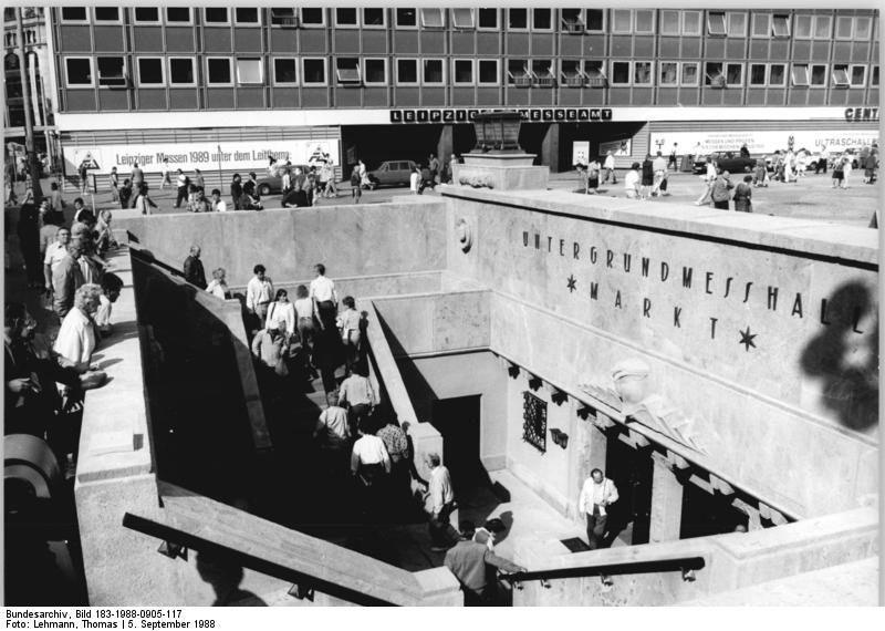 eipzig, "Untergrundmessehalle Markt" ADN-ZB Lehmann 5.9.88 pe Leipzig: Herbstmesse 88- Die "Untergrundmessehalle Markt" wurde nach einer Rekonstruktion zur Herbstmesse wiedereröffnet. In der Eingangszone fallen die Orginalgetreuen Porphyrsäulen und die schmiedseisenrnen Lampen auf. Diese Halle war zur Frühjahrsmesse 1925 als erstes unterirdisches Messehaus der Welt eingeweiht worden. Heute werden auf der 1 600 Quadratmeter großen Ausstellungsfläche Jagd- und Sportwaffen aus der DDR sowie Erzeugnisse der Besen-, Bürsten- und Pinselindustrie gezeigt. / <a href="https://commons.wikimedia.org/wiki/File:Bundesarchiv_Bild_183-1988-0905-117,_Leipzig,_%22Untergrundmessehalle_Markt%22.jpg">Bundesarchiv, Bild 183-1988-0905-117 / CC-BY-SA 3.0</a>, <a href="https://creativecommons.org/licenses/by-sa/3.0/de/deed.en">CC BY-SA 3.0 DE</a>, via Wikimedia Commons